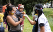 xA Venezuelan mother and her child receives some food from a local charity in the makeshif...