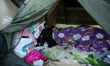 A Venezuelan migrant tries to sleep his tent in the makeshift migrant camp along the highw...