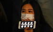 A demonstrator holds a mobile phone reading "Free Hong Kong, Revolution Now" during a prot...