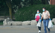 People wearing face masks and rubber gloves to protect them from the novel coronavirus (CO...