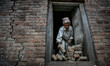 An old man is collecting bricks from his destroyed house. Sankhu, Nepal. May 9, 2015 