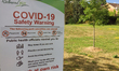 Sign warning people to take precautions due to the novel coronavirus (COVID-19) pandemic a...