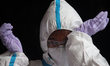 A healthcare worker wipes her sweat during a medical check-up in Mumbai, India on June 30,...