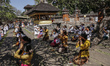Balinese Hindu wears mask and practices physical distancing while praying during Saraswati...