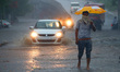Indian People drives through a flooded road during a Heavy Monsoon Rain shower in Ajmer, R...