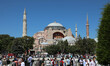 People wait for the first official Friday prayers to start outside Hagia Sophia Mosque on...
