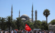 People wait for the first official Friday prayers to start outside Hagia Sophia Mosque on...