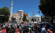 People wait for the first official Friday prayers to start outside Hagia Sophia Mosque on...