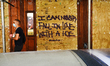People wearing masks walks past a graffiti in Midtown as New York City continues Phase 4 o...