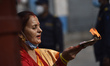 Nepalese devotees offer oli lamps outside the Pashupatinath Temple gate during Teej festiv...