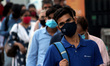 Commuters wearing facemasks as a preventive measure against the Covid-19 coronavirus wait...