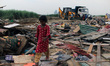 Children are seen outside demolished slum dwellings after demolition drive by the Delhi De...