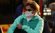 People are seen wearing face masks at a bus stop in central Warsaw, Poland on October 8, 2...