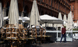 A man walks near closed cafes and terraces on the Capitole square during the 1st day of th...