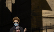 A woman wearing face mask is seen walking on in a centric street of Granada near the Cathe...