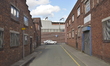 A car travelling in cetral Stockport as two closed factory units stand closed either side...