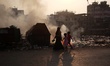 People make their move as garbage fire creates toxic smoke besides a road at Keraniganj ar...