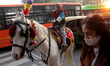 A boy wearing Santa hat sits on a horse outside the Sacred Heart Cathedral on the eve of C...