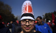 A Protester faction of ruling Nepal Communist Party along with face paint of party logo pa...