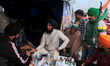 A volunteer provides medical assistance to farmers during a protest against the newly pass...