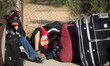 A Palestinian woman looks on as she waits for a travel permit to cross into Egypt, at the...
