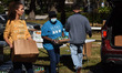 Volunteers distribute food to the needy from the Second Harvest Food Bank of Central Flori...
