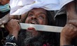 Indian Muslim devotee performs a stunt as he takes part in the religious procession for th...