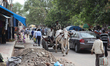 Men drive an ox cart amongst traffic near the Chandni Chowk Market in Old Delhi, India. Ch...