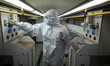 An Iranian health assistant wearing a protective suit check oxygen machines before transfe...