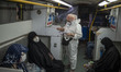 A medical personnel wearing a protective suit checks a document as people who have infecte...