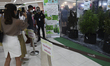 Visitors take photos of a display of hemp plants at the 'Ganja & TTM in The City' fair in...