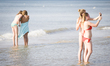 Teenage girls are seen taking selfies at the beach during a hot weather spel on 1st July 2...