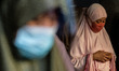 Filipino Muslims wearing face masks as protection against COVID-19 pray outside a mosque i...