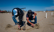 Workers place the poles for the umbrellas on the beach of Margherita di Savoia, Italy  on...
