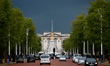 Dark rain clouds fill the sky above Buckingham Palace, seen from The Mall in London, Engla...
