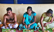 Tamil Hindu devotees eat a traditional vegetarian lunch served on a banana leaf following...