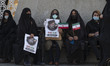 Supporters of the Iranian president elect Ebrahim Raisi hold Raisi’s electoral posters and...