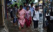Indian women walking  along  the waterlogged street due to heavy rain in Kolkata, India on...