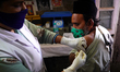 A Health worker Inoculates People with a dose of the Covid-19 coronavirus vaccine at a vac...