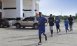 Young baseball players in training jog past the entrance to the Estadio Francisco Micheli...