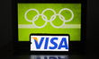 VISA card logo is displayed on a mobile phone screen photographed with Olympic rings symbo...