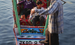 Shikara boatman loads children on to his boat named after the Titanic along Dal Lake in Sr...