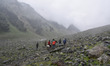 People ride horses during heavy rainfall in Sonmarg tourist spot, Indian Administered Kash...