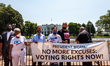 Rally leaders tie themselves to a barricade during a voting rights rally.  They were among...