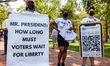 Protesters take refuge in the shade during a voting rights rally at the White House.  LWV,...