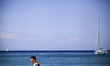 Tourists walk by the Xigia beach as sailing boats as seen on the background in Zakynthos o...