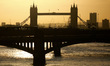 Tower Bridge stands silhouetted in early morning sunlight, seen looking east along the Riv...