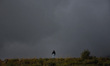 A man walks on the hills of zabarwan mountain range during cloudy weather in Srinagar, Ind...