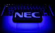 NEC logo displayed on a phone screen and a laptop keyboard are seen in this illustration p...