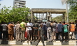 People standout the entrance to site of a collapsed building in Ikoyi district in Lagos, N...